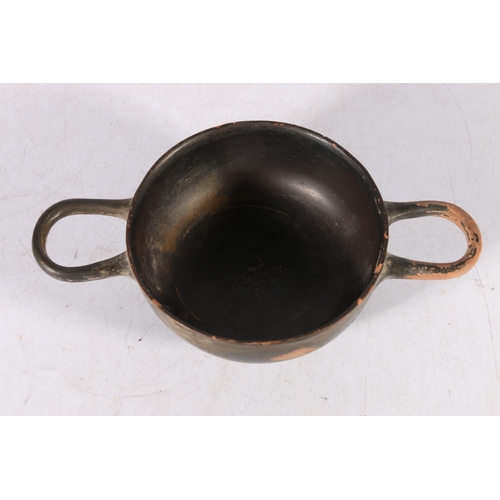 389 - Greek black glazed skyphos of shallow form with two loop handles, impressed palmate decoration to th... 