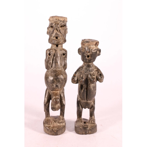 393 - Two carved wood African fertility type figures, one modelled as a standing male with large penis and... 