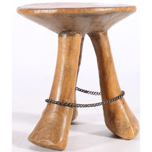 395 - African carved wooden travelling stool, on triple spreading supports, with encircling metal chain, p... 