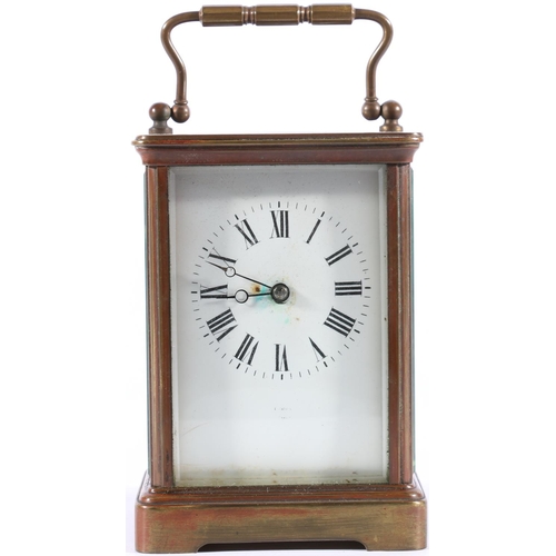 402 - Brass four glass carriage clock, with carry handle and white dial with Roman numerals, 13cm high.