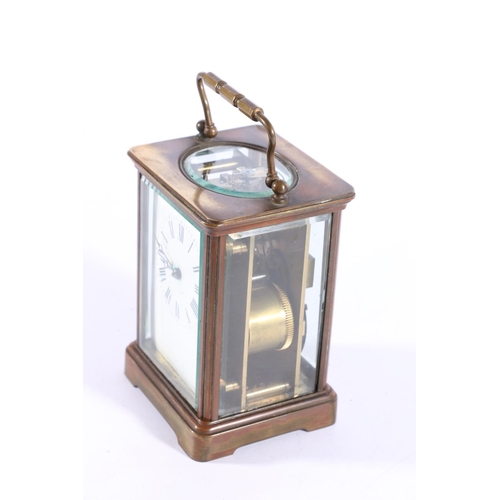 402 - Brass four glass carriage clock, with carry handle and white dial with Roman numerals, 13cm high.