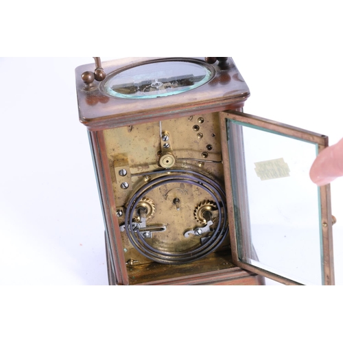 402 - Brass four glass carriage clock, with carry handle and white dial with Roman numerals, 13cm high.