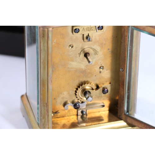 403 - Brass four glass carriage clock, with carry handle and white dial with Roman numerals, the back plat... 