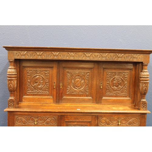 576 - Antique carved oak court cupboard of typical form with Jacobean style profuse carvings depicting thi... 