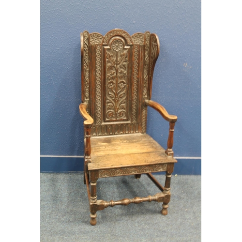 577 - Antique carved oak lambing style armchair with carved floral designs, 130cm tall.