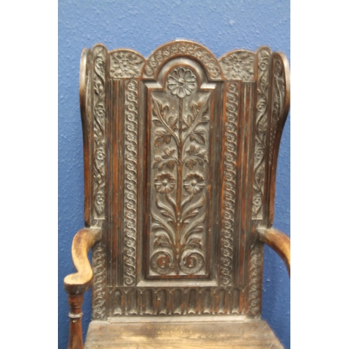 577 - Antique carved oak lambing style armchair with carved floral designs, 130cm tall.