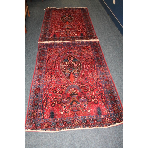 583 - Pair of red ground Eastern rugs, the field decorated with a vase of flowers flanked by multiple bord... 