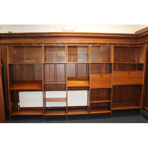 585 - Ladderax teak modular shelving unit, with plaques 'Staples and Co Ladderax', 370cm long.