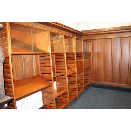 585 - Ladderax teak modular shelving unit, with plaques 'Staples and Co Ladderax', 370cm long.