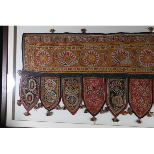 363 - An Indian hanging panel with floral embroidery, the main panel decorated with flowerheads with nine ... 