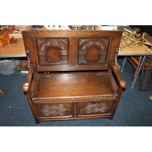 596 - 20th Century heavily carved oak metamorphic monks bench, 107cm x 100cm.