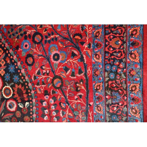 583 - Pair of red ground Eastern rugs, the field decorated with a vase of flowers flanked by multiple bord... 