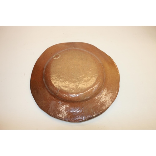 100 - Terracotta pottery dish with slip decoration depicting an eagle, 28cm diameter. 