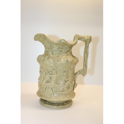 77 - Victorian jug decorated with relief scene of dancing figures, 22cm.