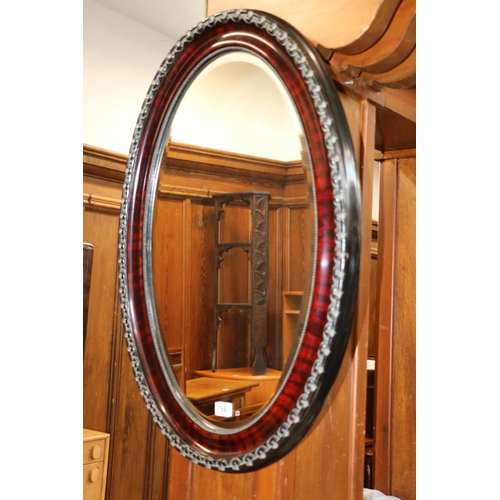 756 - Ebonised framed bevel edge oval wall mirror, 80cm x 52cm.