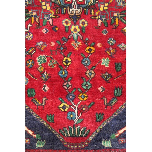 191 - Persian Qashqai wool rug, the red field with central medallion, flowers and birds, two columns with ... 