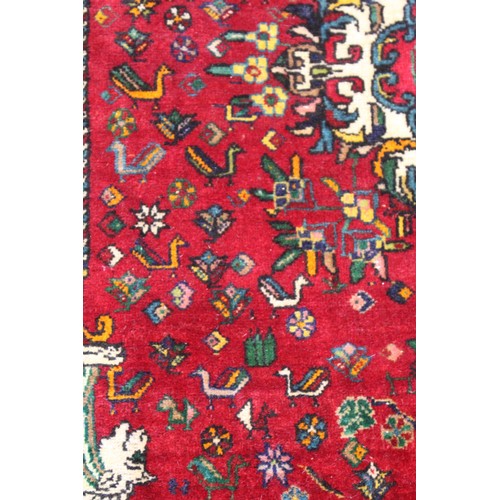 191 - Persian Qashqai wool rug, the red field with central medallion, flowers and birds, two columns with ... 