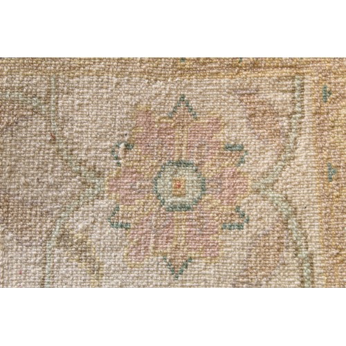 194 - Turkish Usak (Oushak) wool on cotton carpet, the cream ground with pale pastel floral and scroll dec... 