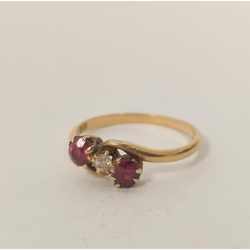 29 - Early 20th century cross-over ring with diamond and two rubies (uncertificated) in gold, probably 18... 