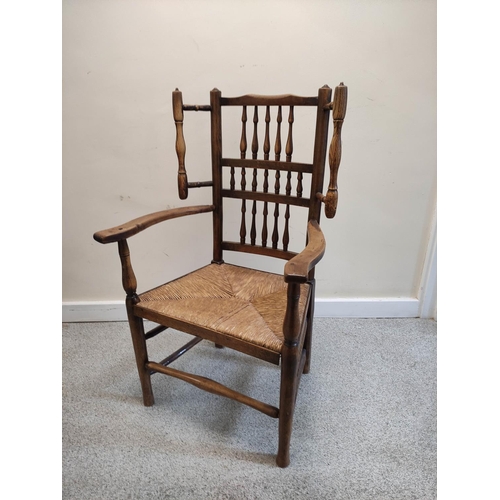 479 - Lancashire-style ash and elm open armchair, with spindle decoration to the back rest, flanked by a p... 