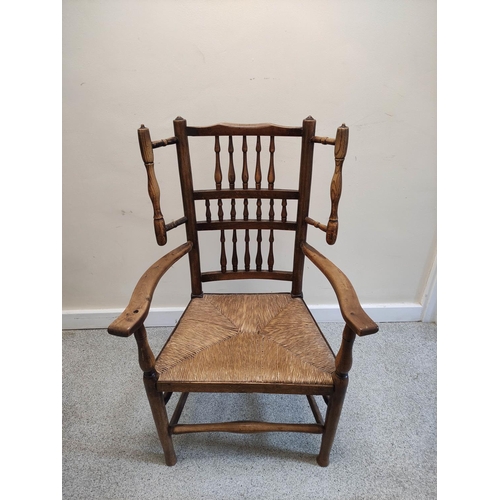 479 - Lancashire-style ash and elm open armchair, with spindle decoration to the back rest, flanked by a p... 