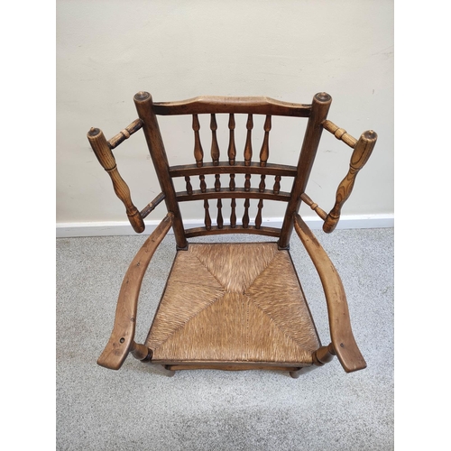 479 - Lancashire-style ash and elm open armchair, with spindle decoration to the back rest, flanked by a p... 