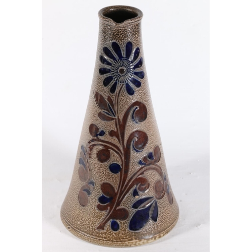 101 - Schilz studio pottery ewer decorated with flowers on a textured brown ground, 27cm.