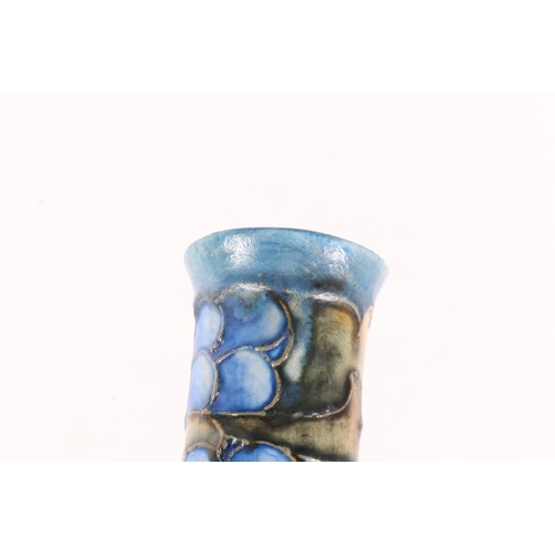 105 - Cranston pottery bottle vase with mottled blue body and pipe lined fruit decoration to the neck, 28c... 