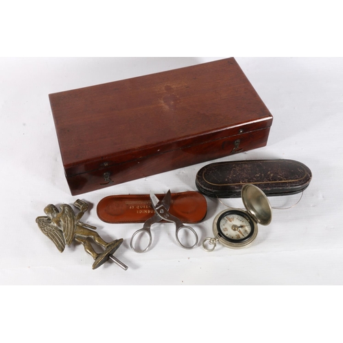 2 - Mahogany hinge top box containing yellow metal spectacles, compass and a brass cherub finial.