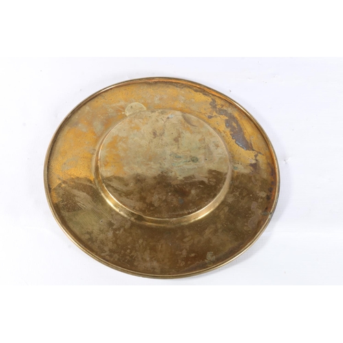 31 - Indian brass dish decorated with relief rings set with four coloured cabochons, 24cm diameter.