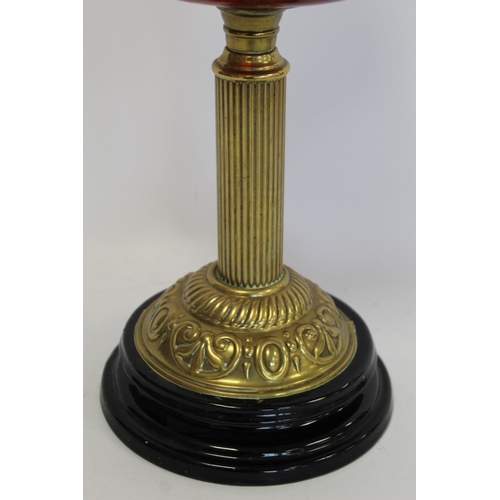 202 - Victorian oil lamp, the cranberry glass reservoir with internal ribbing on brass reeded column and b... 