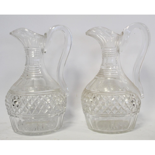 211 - Pair of cut glass wine ewers of baluster form with single scroll handles, blaze, facet and diamond c... 