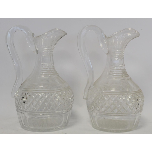 211 - Pair of cut glass wine ewers of baluster form with single scroll handles, blaze, facet and diamond c... 