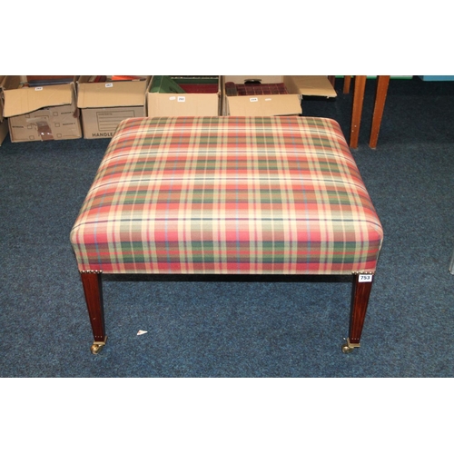 753 - Large tartan fabric footstool on square tapering supports capped with brass castors.