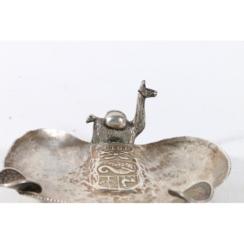 29 - Peruvian alpaca or llama decorated ashtray formed from a hammered Peruvian coin, 7cm.