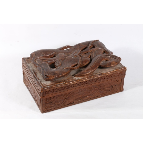 54 - Heavily carved oriental box with dragon decoration, 23cm.