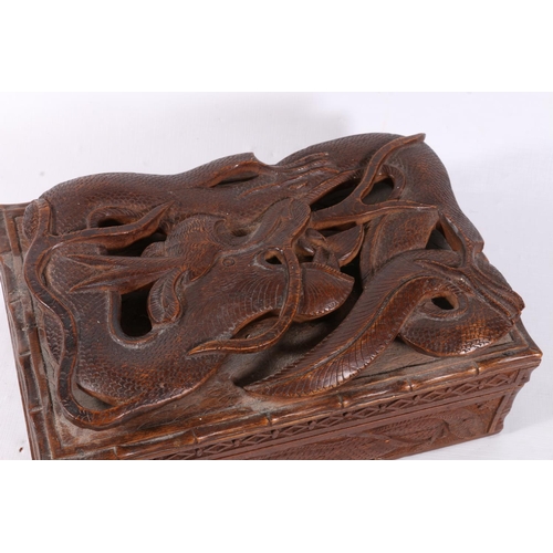 54 - Heavily carved oriental box with dragon decoration, 23cm.