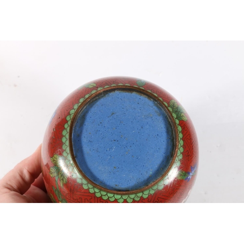 64 - Chinese cloisonne jar and cover decorated with flowers on a red ground, 17cm.