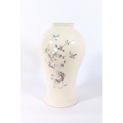 68 - Oriental cream ground lacquered vase decorated with mother-of-pearl and abalone tree scene, 24cm.