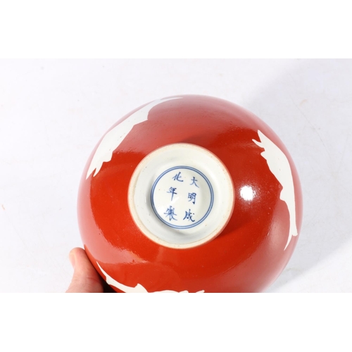 457 - Chinese red ground bowl with fish decoration and six character mark to base, 16cm diameter.