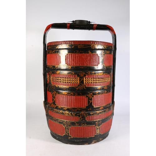 493 - Chinese wicker wedding basket with black lacquer and gilt decoration and red ground, 60cm tall.