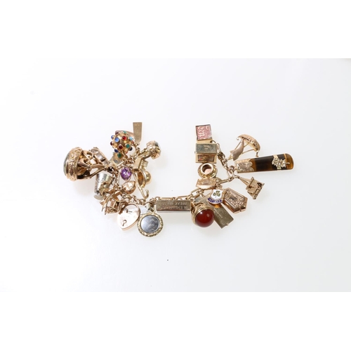 110 - 9ct gold charm bracelet with thirty two dependant charms most stamped for 9ct gold, 98.8 grams