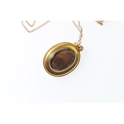 129 - 9ct gold necklace, with yellow metal mourning locket set with single red cabochon, 66cm long, 10.1g ... 