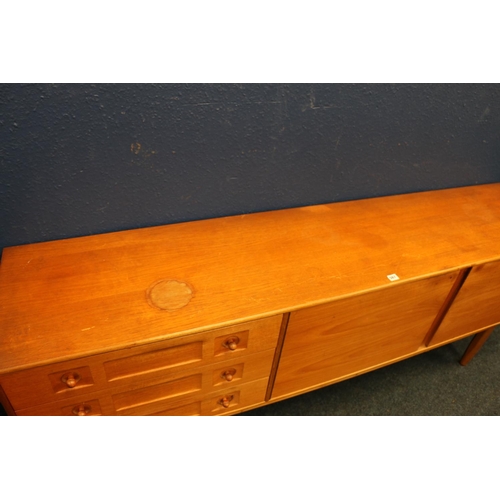 567 - Mid-century teak sideboard, having three drawers and two panel doors, raised on turned supports, in ... 