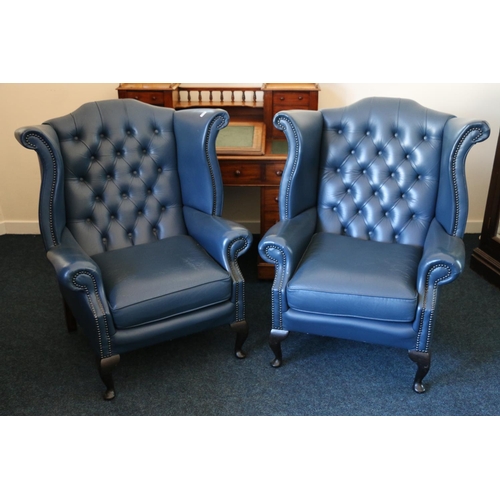 578 - Pair of blue leather button back wing chairs, raised on cabriole supports, with fire labels.