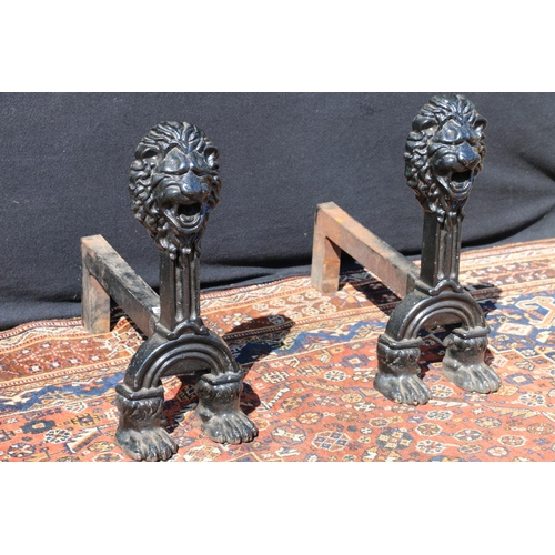 586 - Pair of Victorian anthropomorphic cast iron firedogs, with lion mask finials, raised on paw feet, 50... 