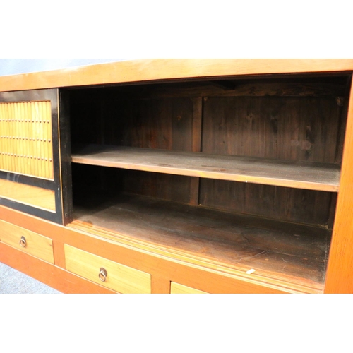 591 - Contemporary Japanese sideboard, having sliding door cupboard top and four base drawers, 183cm long.