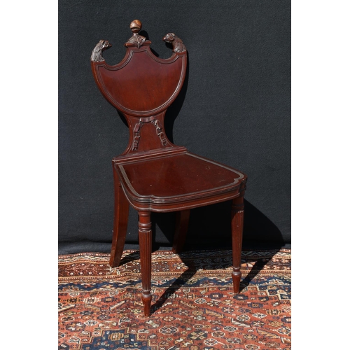 595 - Victorian mahogany hall chair, having knight and griffin finials on a shield shape back, with ribbon... 