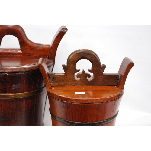 247 - Two Chinese stained wood rice carriers of bucket form, with covers, 33cm high, and another, smaller.... 