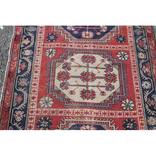 313 - North west Persian hand-knotted rug decorated with three floral and geometric octagonal medallions t... 